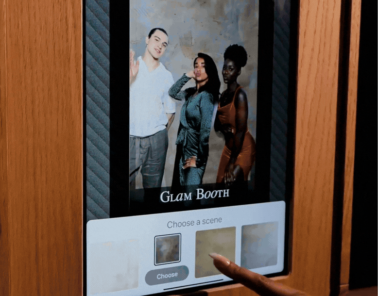 Interactive digital glam booth screen showing friends posing and selecting a custom photo background.