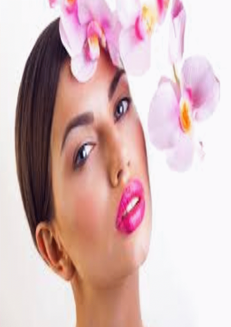 visage d'une femme maquillée avec une orchidée blanche et violette dans les cheveux.