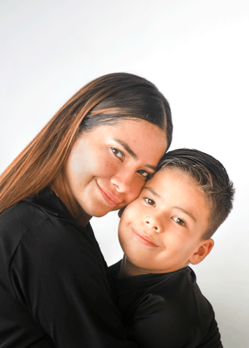Retrato de madre e hijo, rostros juntos y mirando a la cámara, en una imagen emotiva.