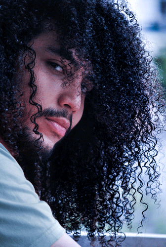 Hombre de cabello afro mirando a la cámara, enfoque en detalle de su cabello.