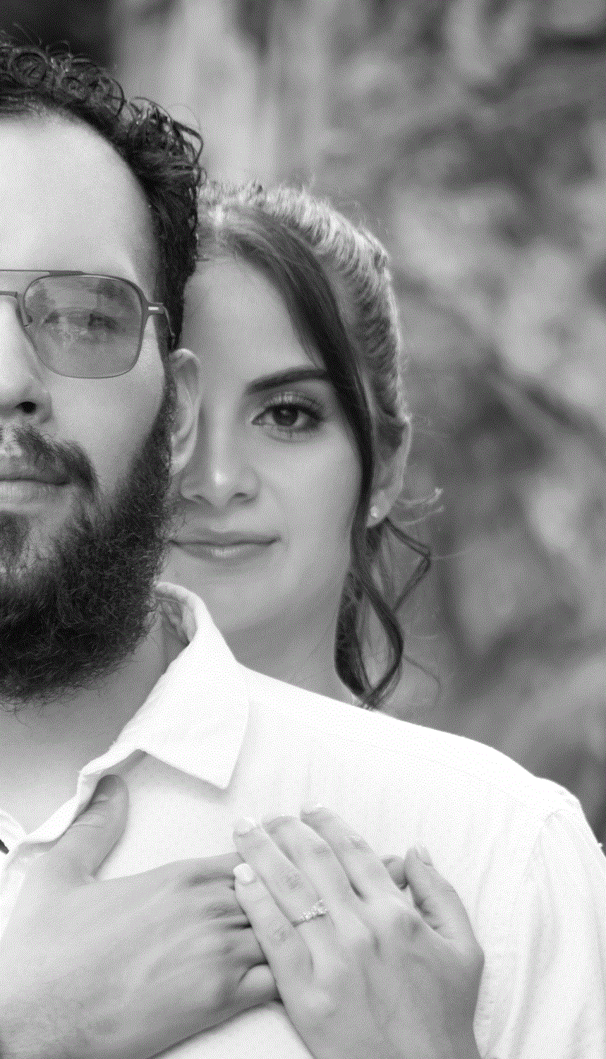 Retrato de pareja comprometida, mostrando el anillo de la novia, en blanco y negro.