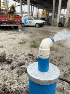 poço artesiano em funcionamento com água jorrando e caminhão da Artzian ao fundo em Curitiba