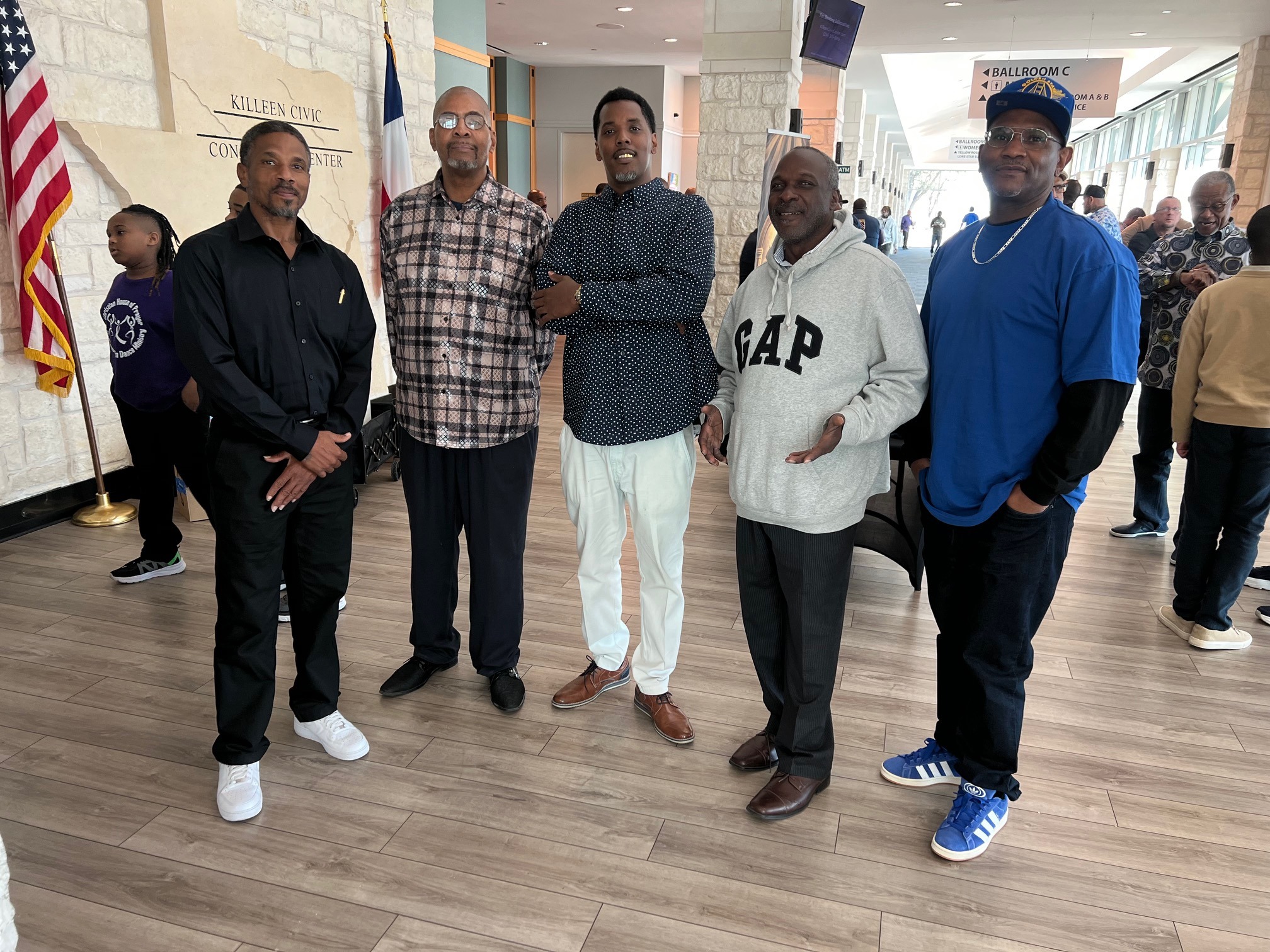 Group of five men standing together in the hallway