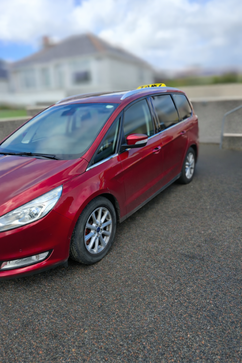 Side view of AW Taxis red vehicle