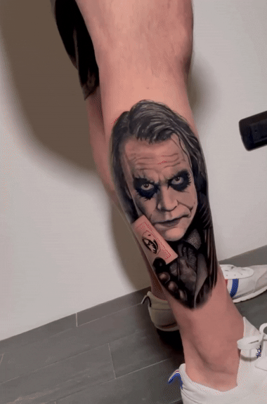 Tatuaggio ritratto realistico del Joker di Heath Ledger sulla gamba eseguito da Horidoku 