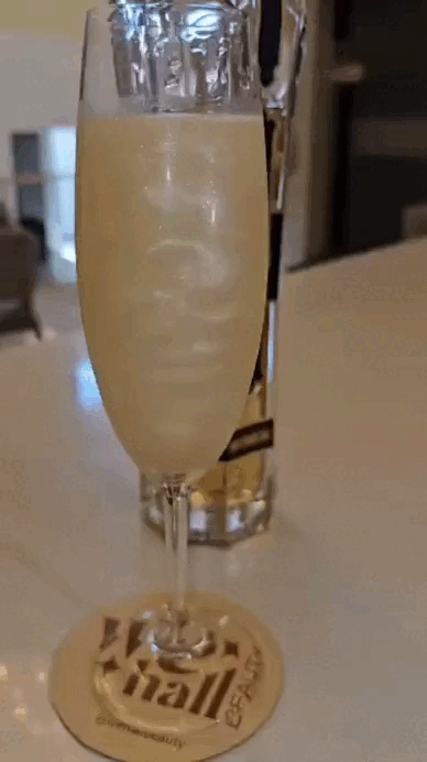 Drink Tornado feito com licor Saint German, de cor dourado brilhante servido em uma flute no We Hall Beauty, o melhor salão 