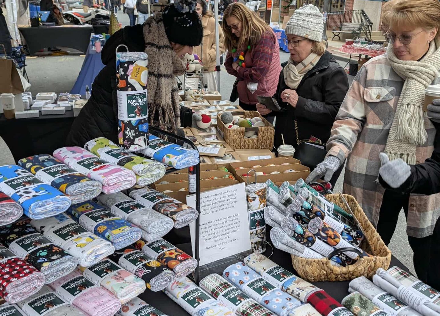 Laura displaying reusable paperless towels and eco-friendly products at a local market