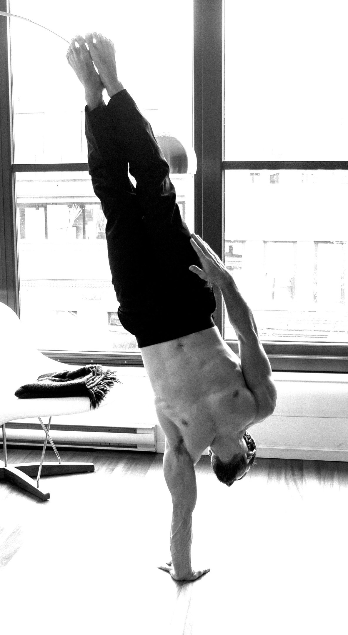 Atleta manteniendo un handstand de un brazo