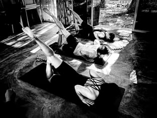 Practioners practice Locust Pose in a yoga class