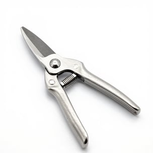 Close-up of a sharp pruning shear resting on freshly cut branches with green leaves.