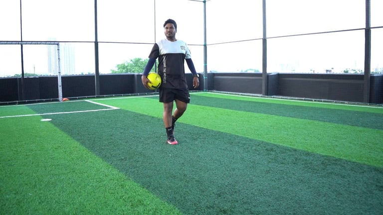 a man in a black shirt and shorts playing soccer