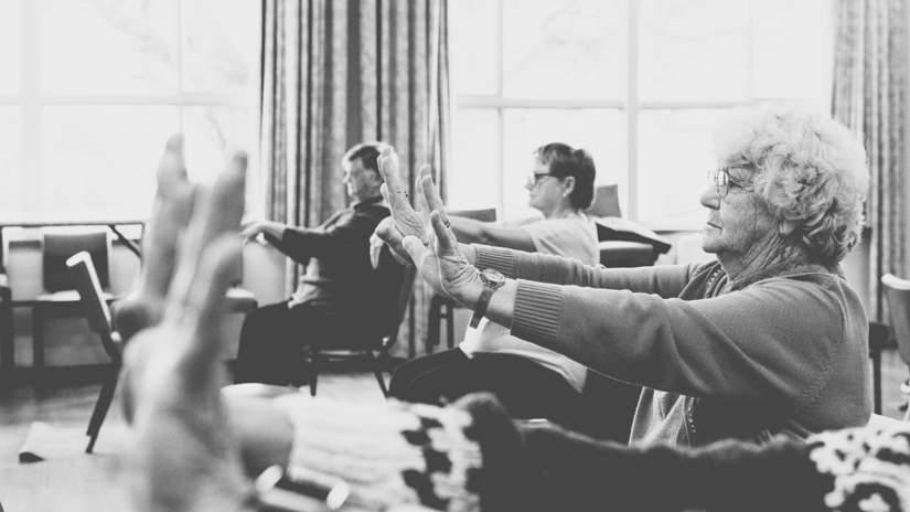 Chair Yoga class hands raised and wrists bending