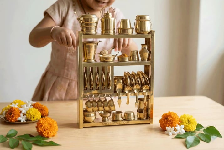 Girl playing with miniature brass kitchen set