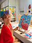 Une femme souriante peint un flamant rose sur une toile lors d’un atelier in strasbourg