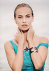 A close-up of a woman with wet, with accessorized with a black star-themed bracelet, necklace