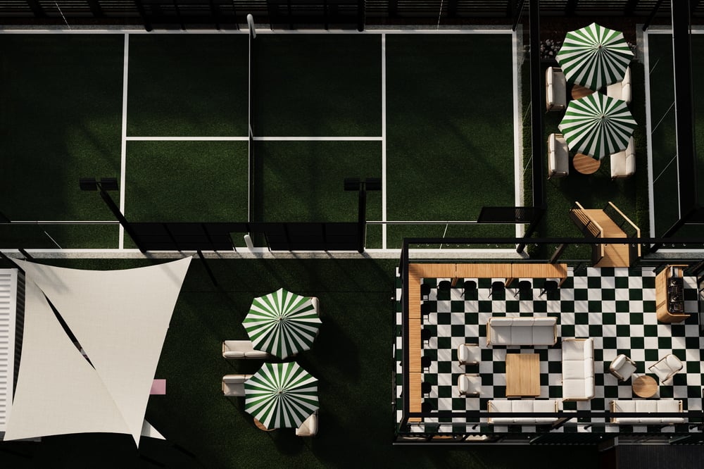 Players rallying on a padel court with glass walls