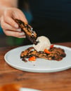 a person is eating a dessert on a plate