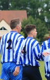 3 adultes en tenue de foot