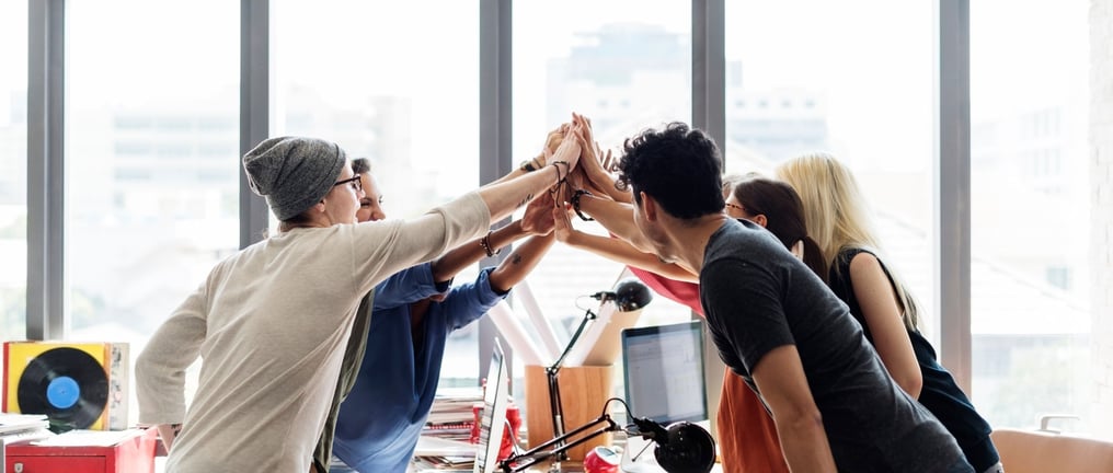 a group of co-workers high fiving