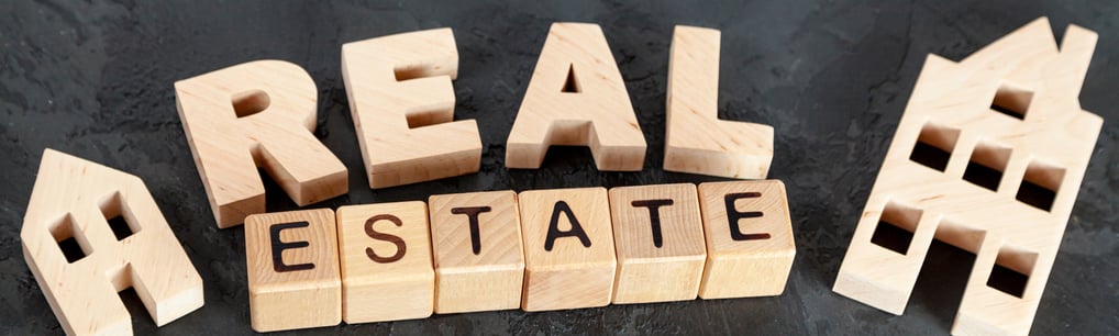 a wooden block with the words real estate written on it USA Los angeles