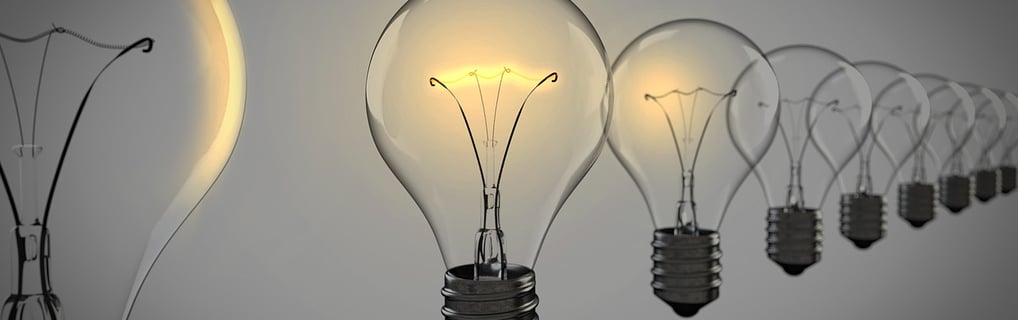 Row of lightbulbs with one glowing, symbolizing insight and breakthrough