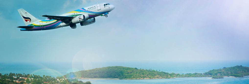 a plane flying over a lush green hillside