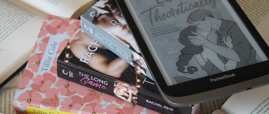 a pile of books with a kindle on top