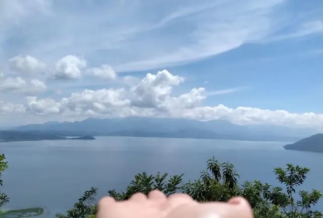 a person holding their hand up to the camera lago de yojoa hijasdelamontanahn