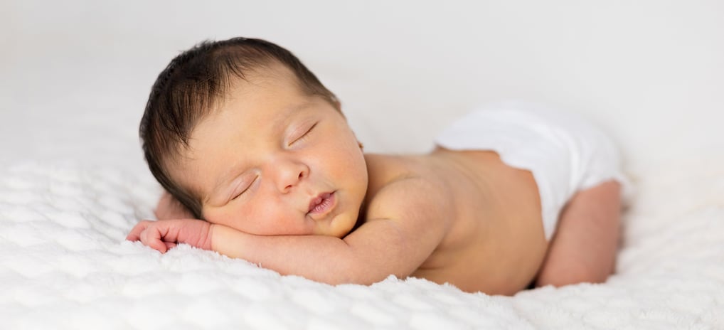 Sessió de fotos newborn a Girona amb una bebè recent nascuda dormint en estudi fotogràfic
