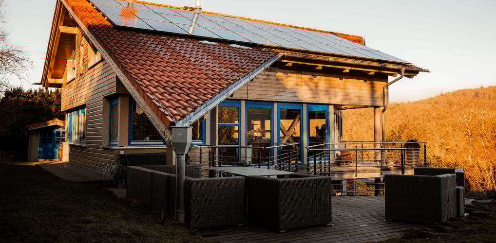 a wooden house with terraces and a solar paneled roof