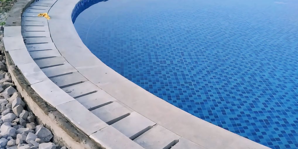 Kolam renang berbentuk lingkaran dan keramik berwarna biru.