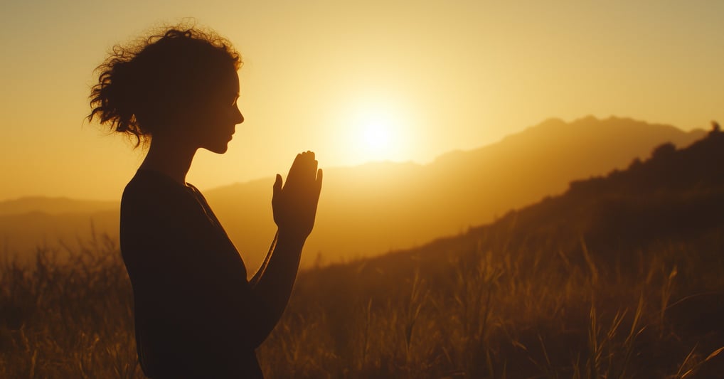 Silhouette of a woman praying at dawn/sunset