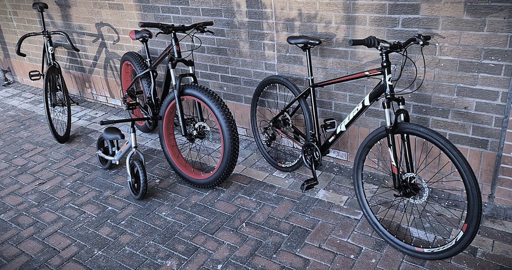 two bikes parked next to each other on a brick wall