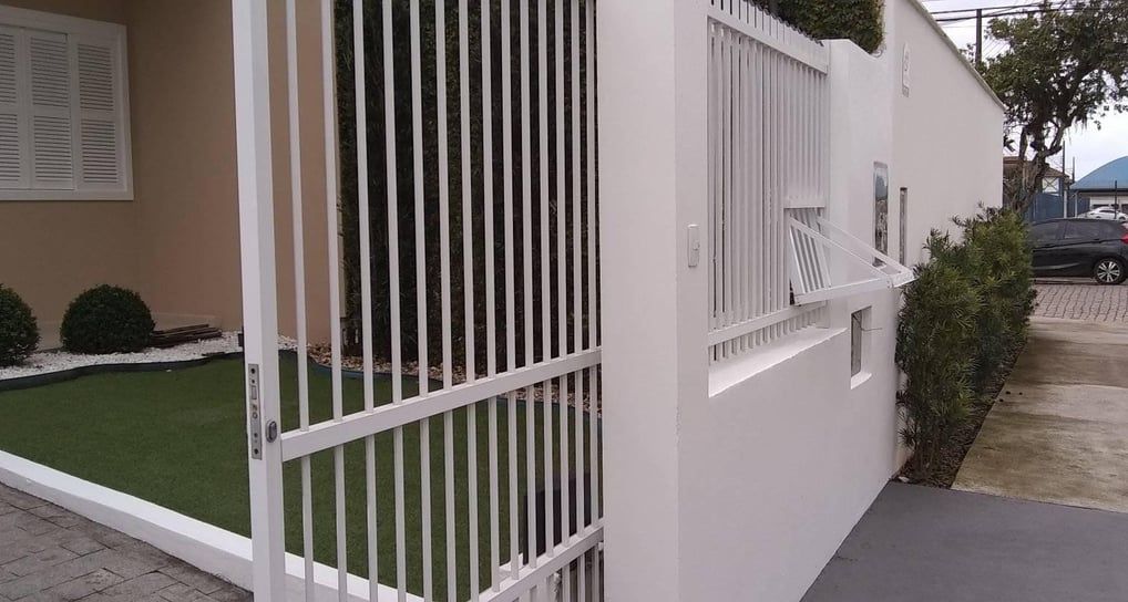Um portão e uma cerca recém pintada de branco