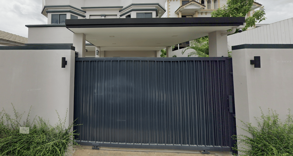 a gate in front of a this beautiful Thai house for sale