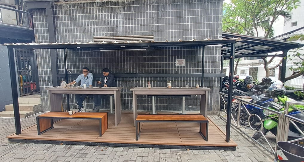 a man and woman sitting at a table with a dog in the background