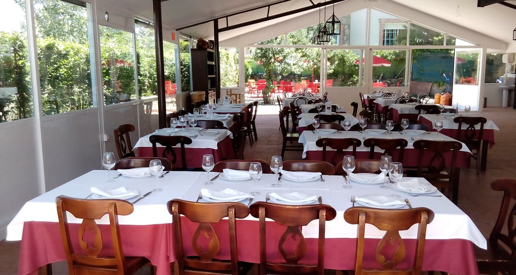 a restaurant with tables and chairs and a table with plates and glasses