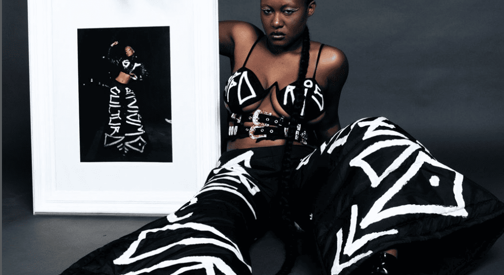 Modelo com visual de streetwear, calça cargo e camiseta da SPPARIS, refletindo a mistura de arte urb