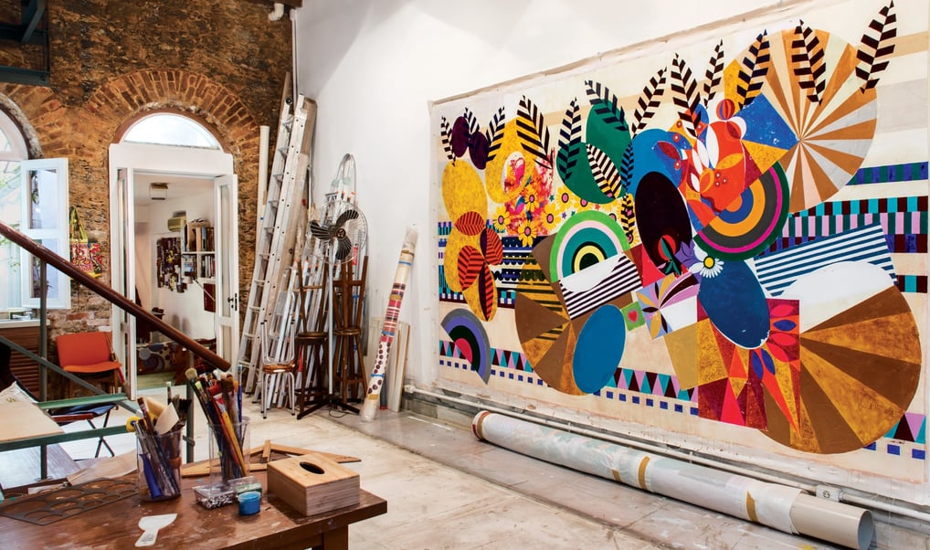 Ateliê luminoso de Beatriz Milhazes com suas obras coloridas e detalhadas em processo.