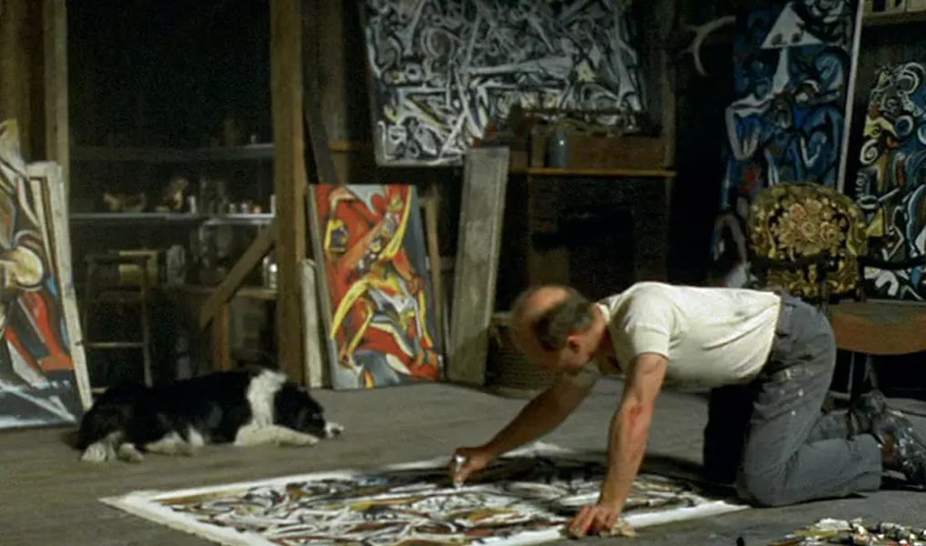 Ateliê de Jackson Pollock com telas no chão, mostrando sua técnica de dripping.