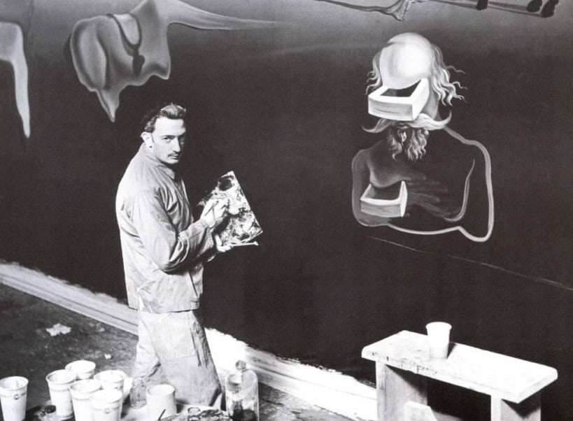 Ateliê surreal de Salvador Dalí, decorado com objetos estranhos e suas pinturas.