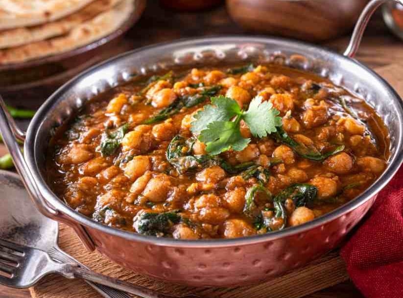 chickpea curry in a balti dish garnished with coriander