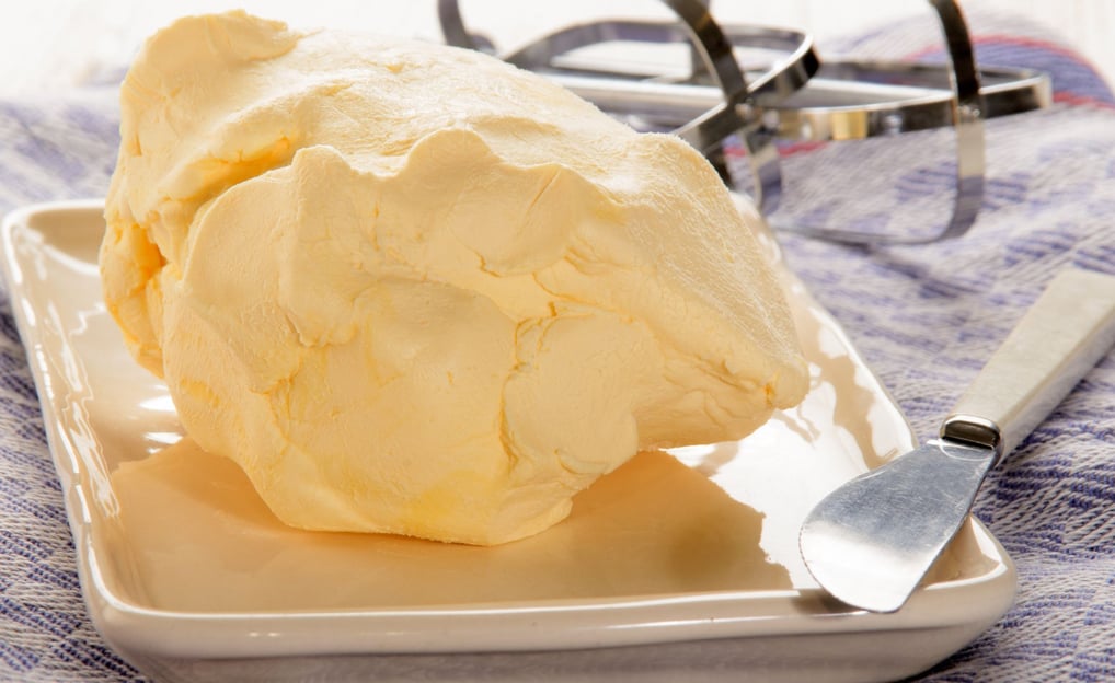 Homemade butter on a tray with a knife