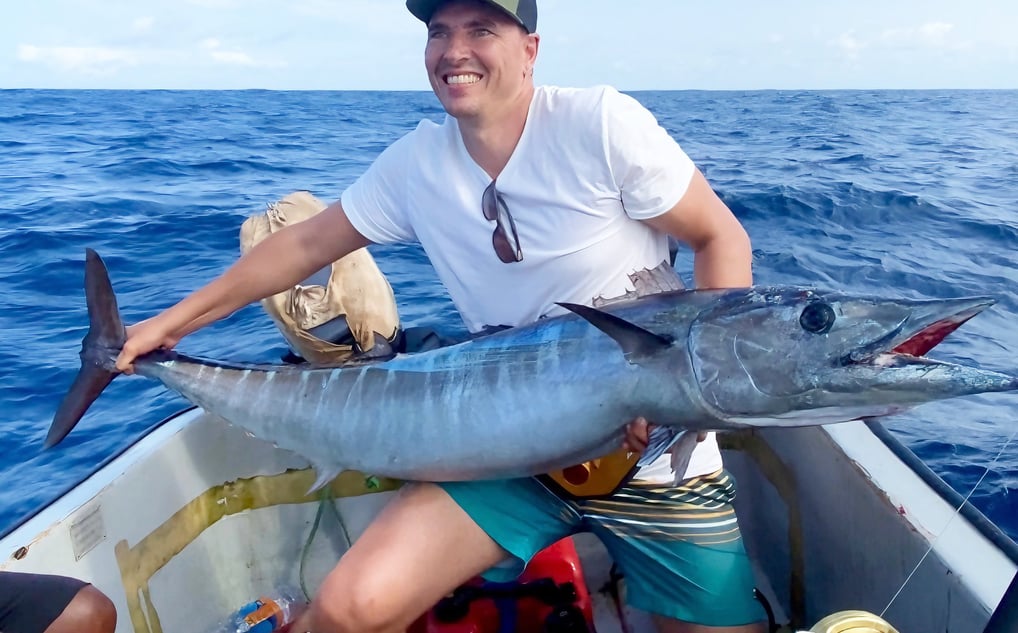 Happy angler holding a giant wahoo caught on a Half-Day Fishing Charter in Zanzibar