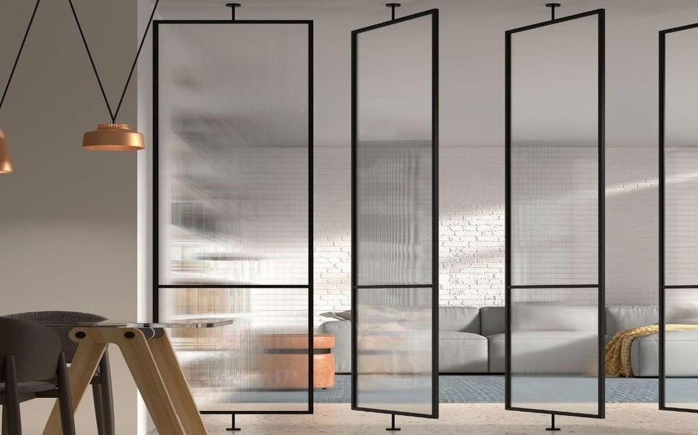 Puerta pivotante de cristal con marco negro en pasillo luminoso de diseño minimalista