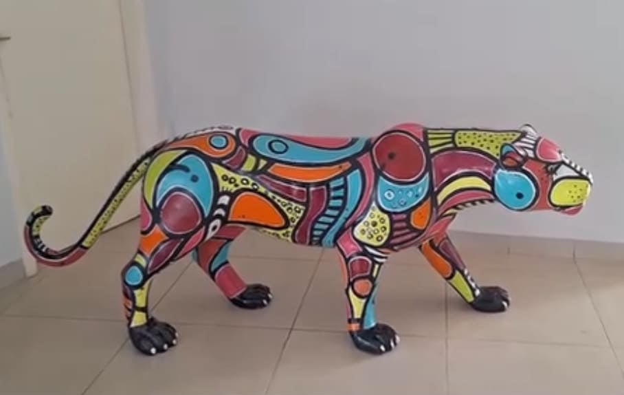 Detalhe da escultura de onça pintada com padrões gráficos vibrantes por Aloísio Marinho