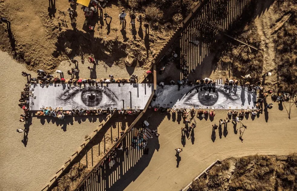 Vista aérea da instalação fotográfica de larga escala de JR, mostrando olhos gigantes impressos