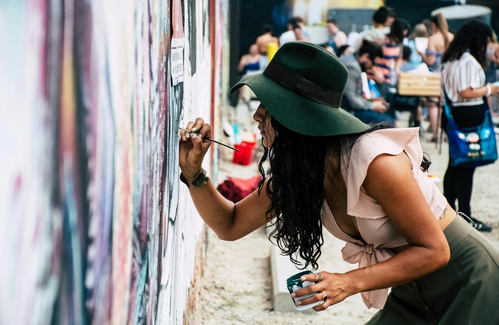 Um coletivo de mulheres, criando um mural de arte urbana.