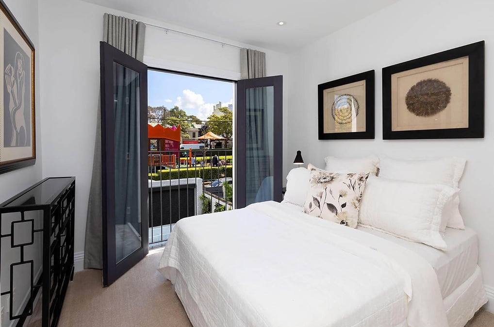 Elegant bedroom design in a renovated Victorian house, with French doors opening to a Juliet balcony