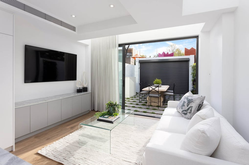 Modern living room with white sofa, custom TV cabinet, and ducted air conditioning system